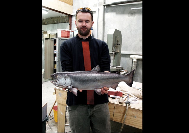 An animatronic trout, held by Dominic Taylor, principle designer at Human Dynamo Workshop.